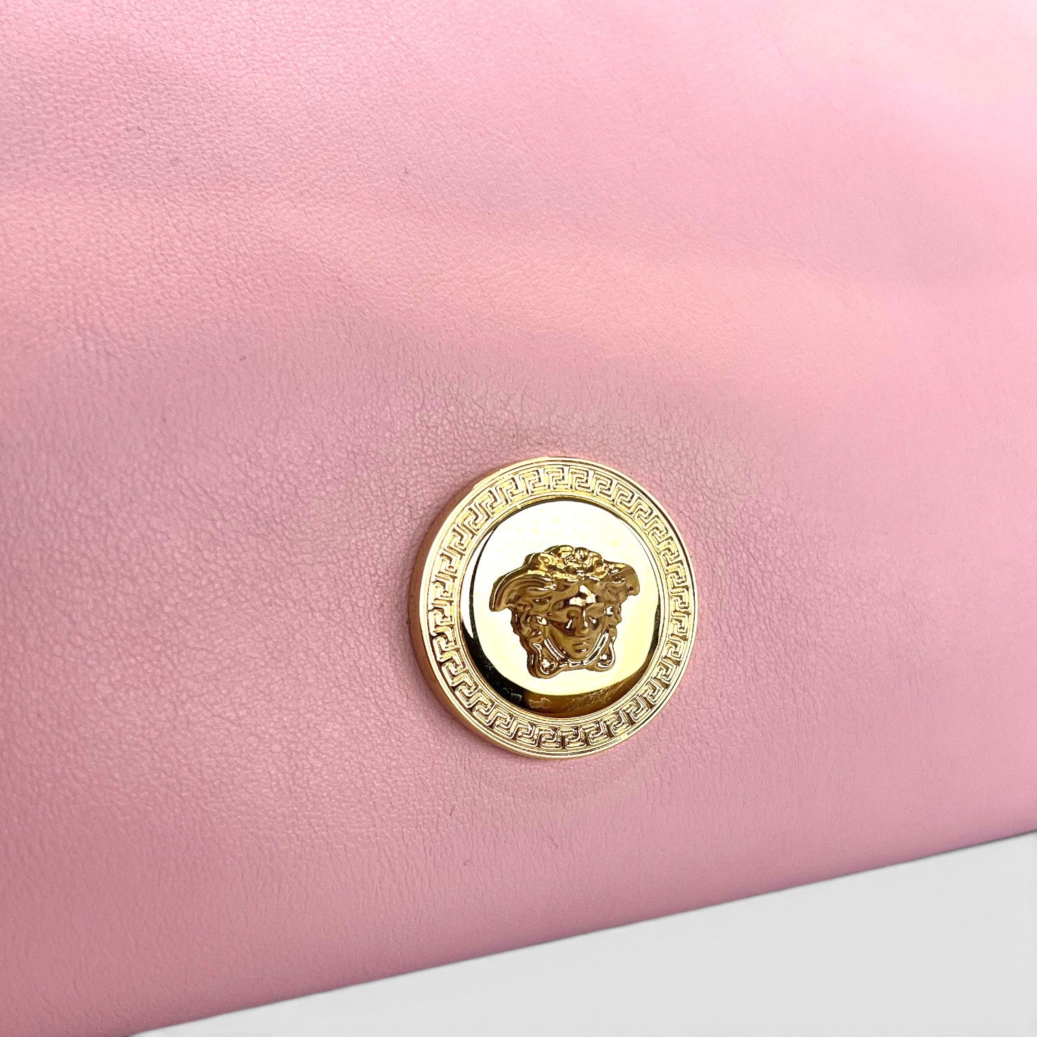 Supplied Fashion rose pink leather Versace Medusa crossbody bag featuring signature gold-tone Medusa head hardware.