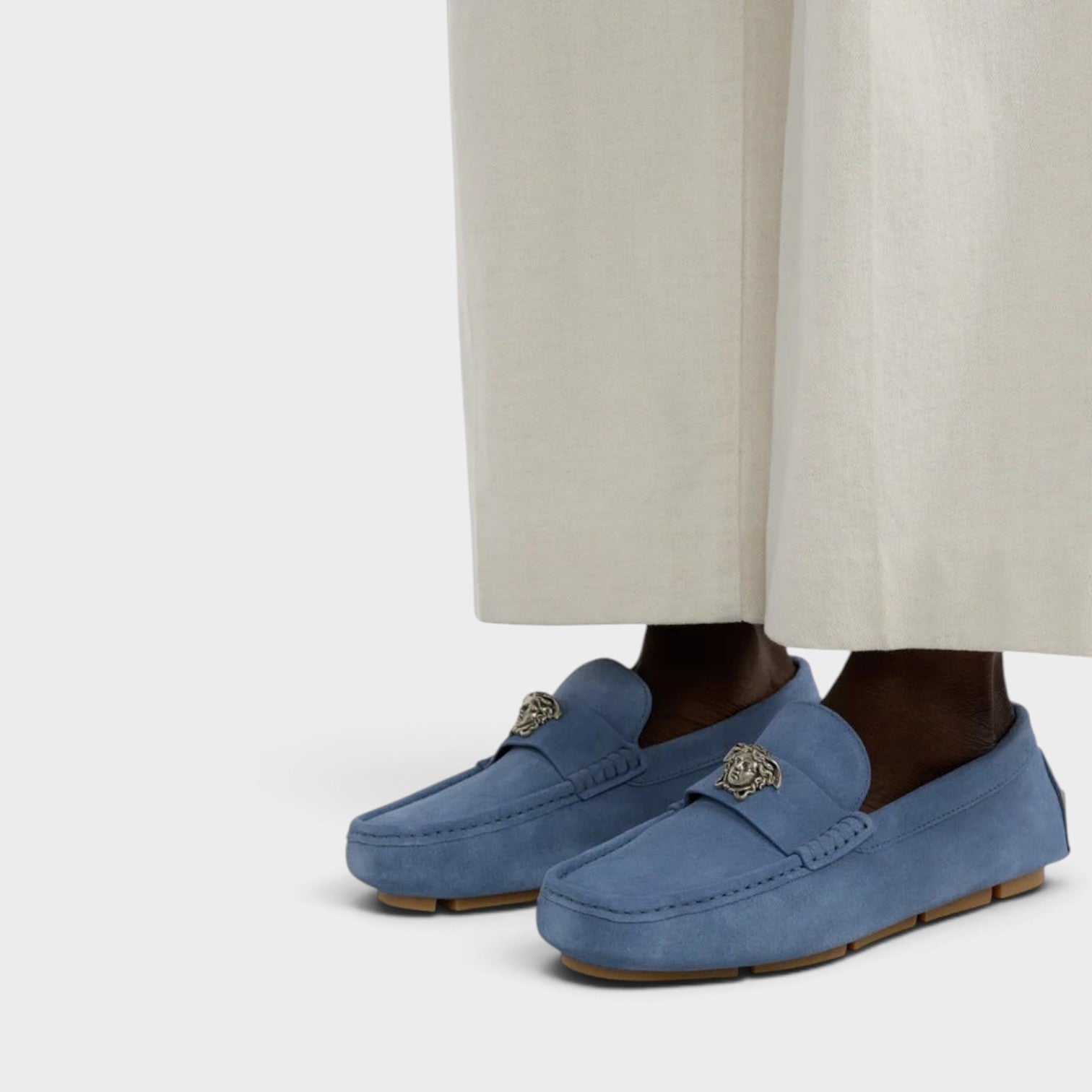 Supplied Fashion stone blue suede Versace La Medusa driver loafers with iconic silver emblem on a model