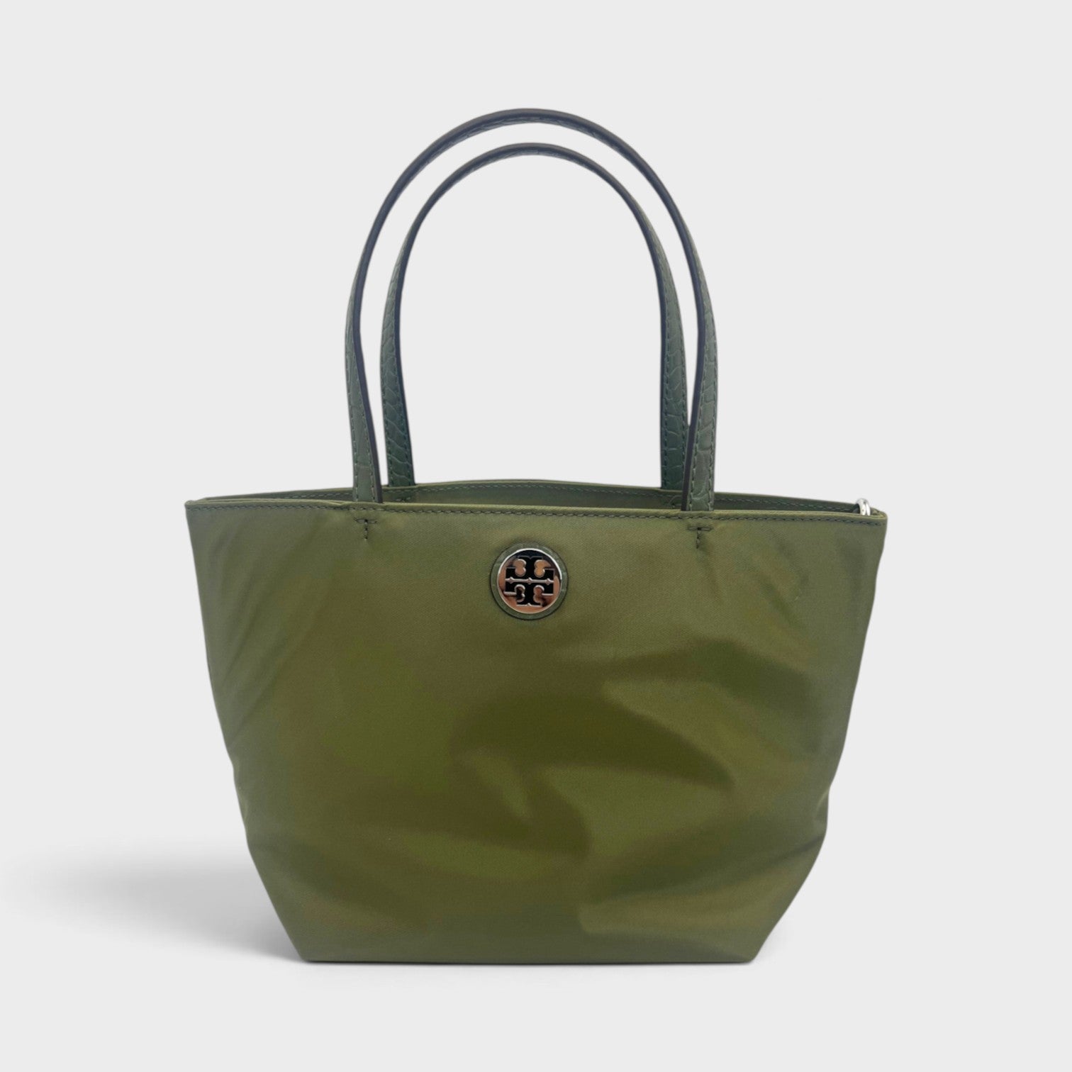 Supplied Fashion Tory Burch mini tote bag in green khaki nylon with dual top handles and a metallic logo emblem.