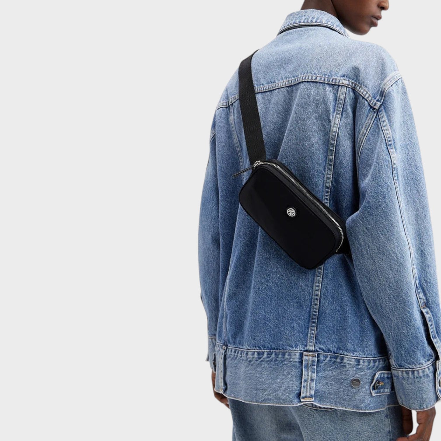 Supplied Fashion Virginia black nylon belt bag worn cross-body over a denim jacket
