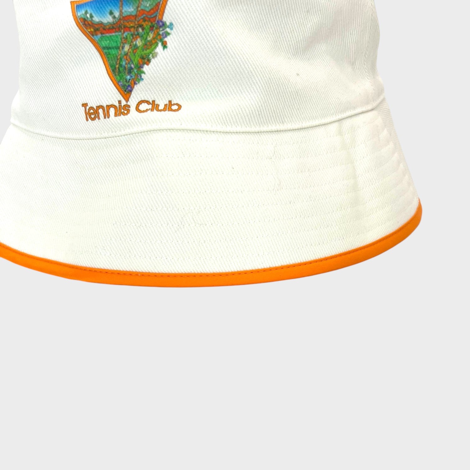 Supplied Fashion white bucket hat featuring a colourful Tennis Club graphic and orange trim detail.