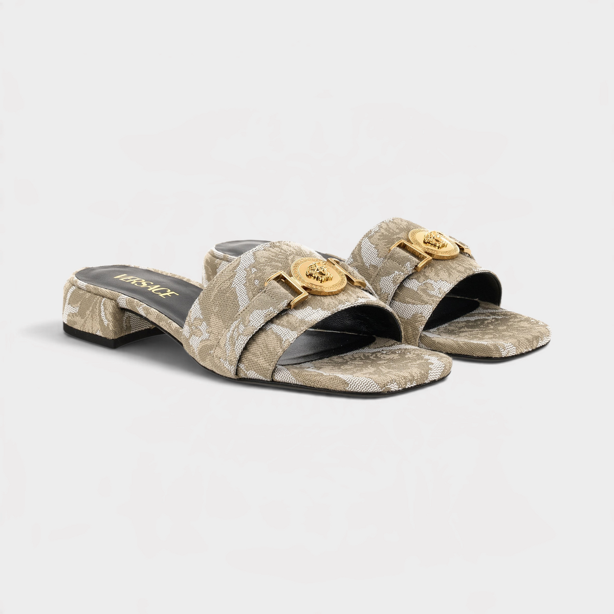 Supplied Fashion beige fabric sandals featuring the iconic gold Versace Medusa head emblem and a low block heel.